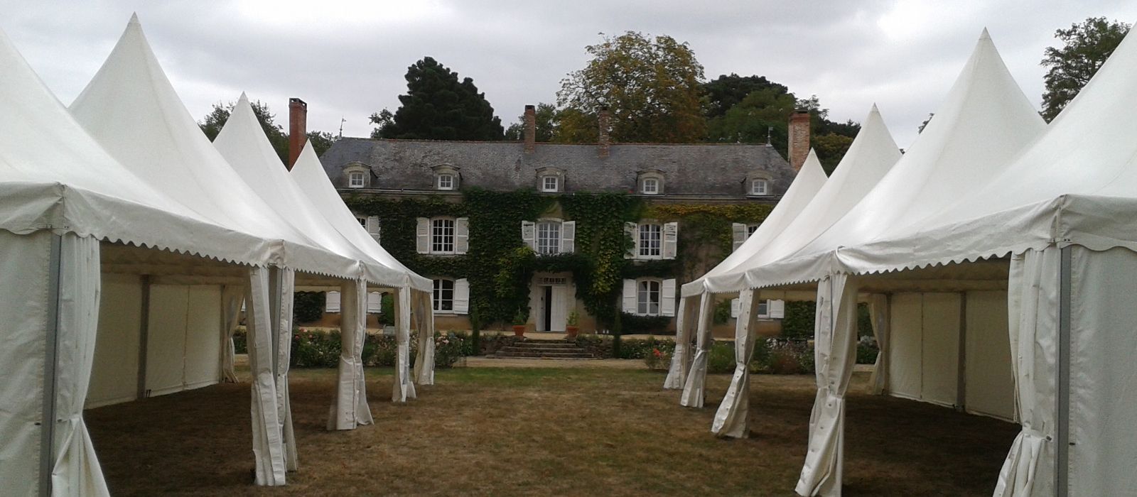 Tentes Garden alignées devant une demeure en pierre