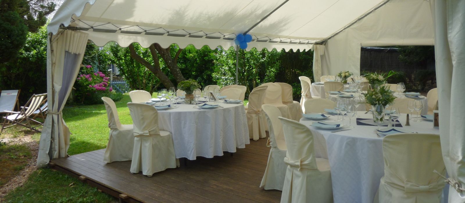 Tables et chaises décorées sous un chapiteau